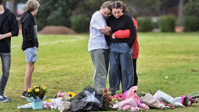 People embrace at the scene where Eurydice Dixon was found dead at Princes Park. Picture: Tony Gough