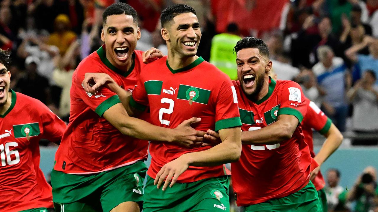 TOPSHOT - Morocco's defender #02 Achraf Hakimi (C) celebrates with teammates after converting the last penalty during the penalty shoot-out to win the Qatar 2022 World Cup round of 16 football match between Morocco and Spain at the Education City Stadium in Al-Rayyan, west of Doha on December 6, 2022. (Photo by JAVIER SORIANO / AFP)