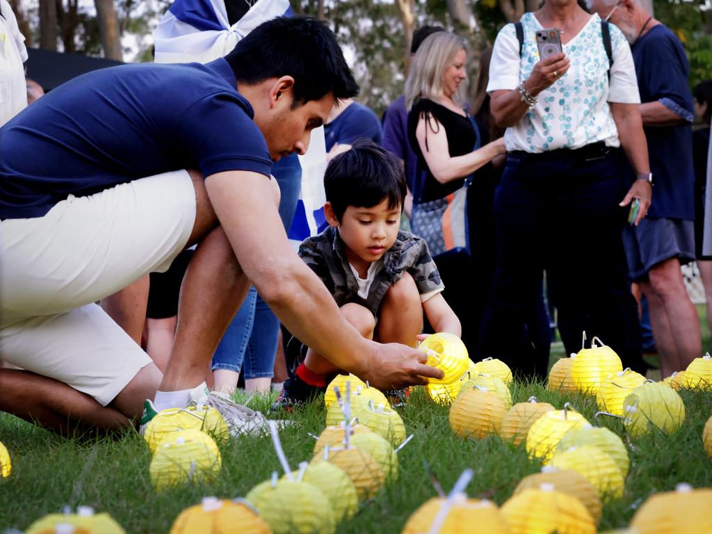 Aaron Tran lights a lantern with his son Elisha Tran 5. Picture: Steve Pohlner