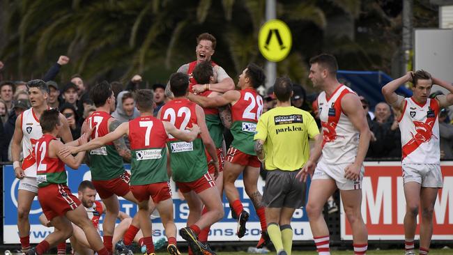 Aaron Ludewig (top) celebrates with team mates after kicking the winning point. Picture: Andy Brownbill.