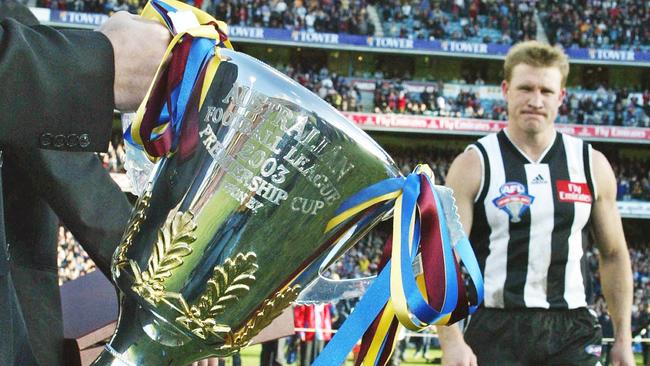 Buckley walks past the 2003 premiership cup on his way to collect a Norm Smith medal that summed up his 478 games as a player and coach – so near, but yet so far away.