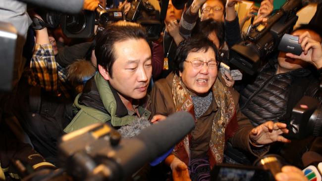 A relative of a passenger who was travelling on board the missing Malaysia Airlines flight MH370 is escorted in a hotel in Beijing in 2014. Picture: AFP