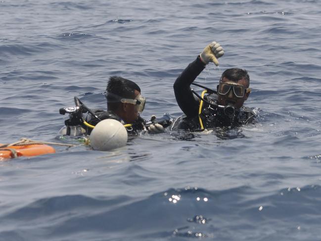 A navy diver on board a search vessel said his team found the orange cylinder containing the recorder among debris on the muddy sea floor. Picture: AP