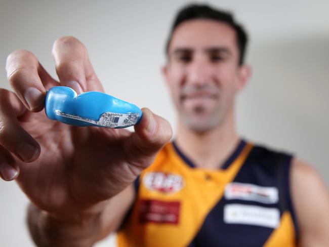 Mouthguard sports revolution. Ex north Melbourne defender Michael Firrito with the new microchipped mouthguard developed in Australia touted to be the future of concussion detection  . Pic: Michael Klein