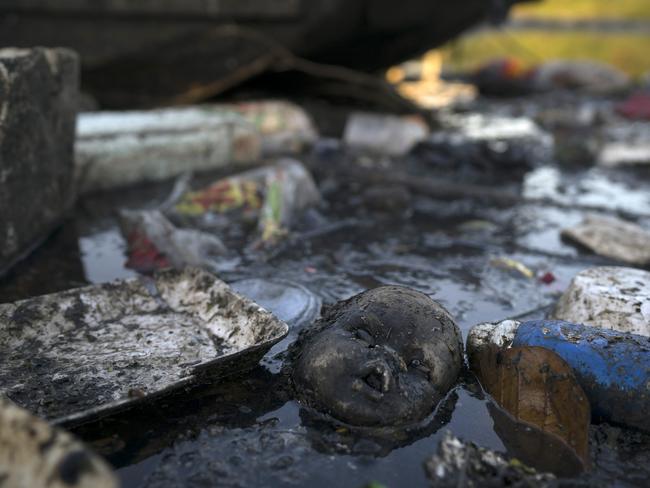 A doll's head floats in the polluted waters of a canal at the Mare slum complex in Rio.