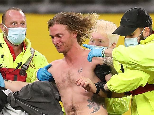 PERTH, AUSTRALIA - JULY 16: A pitch invader is escorted from the field of play by security during the round 7 AFL match between the Geelong Cats and the Collingwood Magpies at Optus Stadium on July 16, 2020 in Perth, Australia. (Photo by Paul Kane/Getty Images)