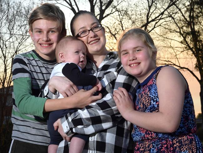 Kylie Reynolds with children Jay 12, Lachlan 17 weeks and Kayla, 10, near their home in Moorebank.