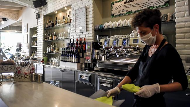 For many regional workers, life has to go on, even if a mask and gloves are required. Picture: Claudio Furlan/AP