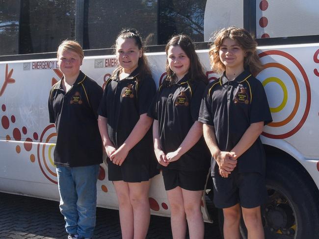 Hackham West Primary School students Theo, 11, Sheniqua, 10, Matilda, 11 and Lucas, 11, with the school's bus. Picture: Supplied