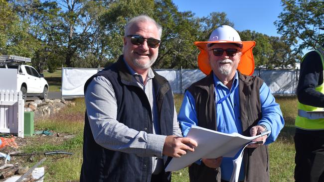 Doug Webber and a council officer look over plans for construction.