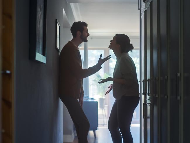 Young Couple Arguing and Fighting. Domestic Violence Scene of Emotional abuse, Stressed Woman and aggressive Man Having Almost Violent Argument in a Dark Claustrophobic Hallway of Apartment.