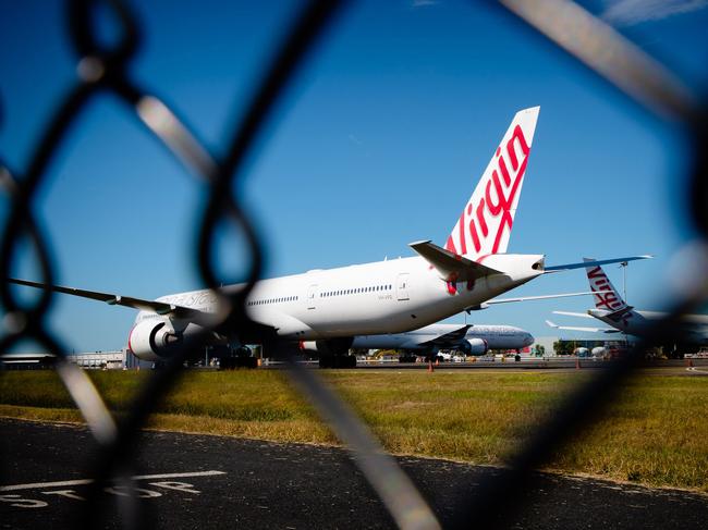 Virgin Australia aircraft are seen parked on the tarmac at Brisbane International airport on April 21, 2020. - Cash-strapped Virgin Australia collapsed on April 21, making it the largest carrier yet to buckle under the strain of the coronavirus pandemic, which has ravaged the global airline industry. (Photo by Patrick HAMILTON / AFP)