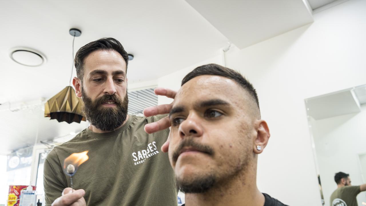 Sarge Tirabzon of Sarges Barber demonstrates traditional Turkish ear hair removal technique on staff member Antoine Roma.