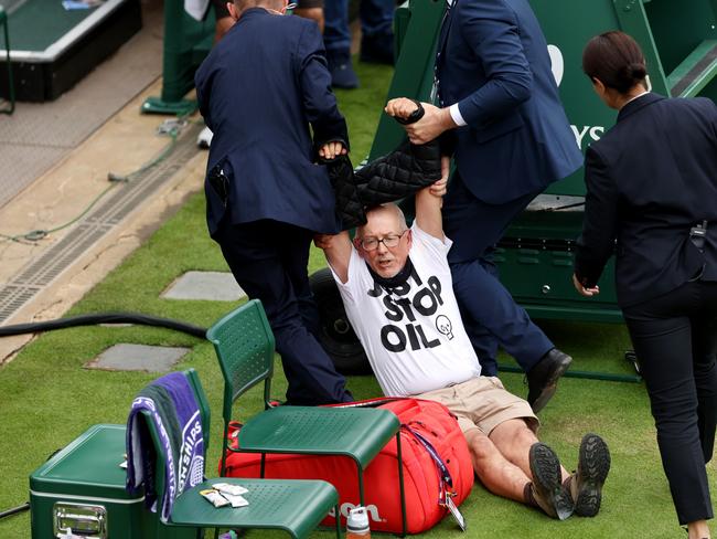 LONDON, ENGLAND - JULY 05: A protester is taken away by security on court 18 after a Just Stop Oil protest during the Women's Singles first round match between Katie Boulter of Great Britain and Daria Saville of Australia during day three of The Championships Wimbledon 2023 at All England Lawn Tennis and Croquet Club on July 05, 2023 in London, England. (Photo by Julian Finney/Getty Images)