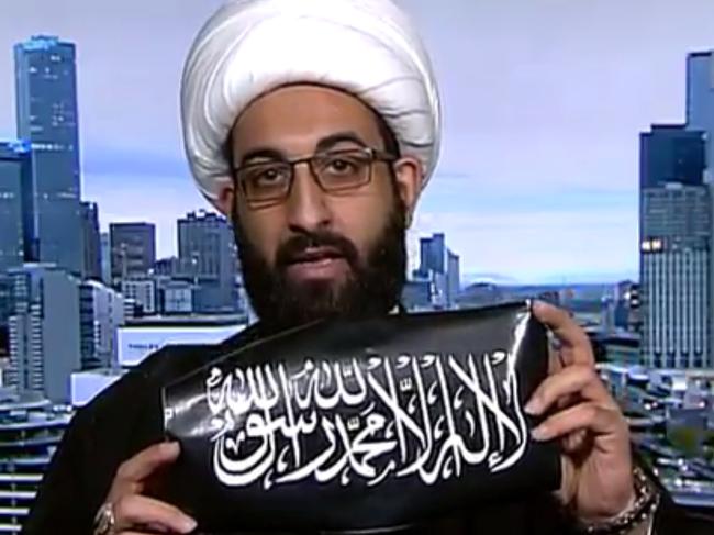 Imam Tawhidi shows off the al-Qa’ida branded sticker he says he bought in Melbourne this week.