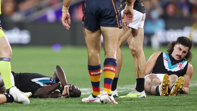 Aliir Aliir, left, on the ground with Lachie Jones of the Power after they collided during the Showdown. Picture: Sarah Reed/AFL Photos via Getty