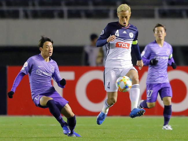 Kohei Shimizu (R) of Japan's Sanfrecce Hiroshima and Keisuke Honda (C) of Australia's Melbourne Victory fight for the ball during their AFC Champions League group stage football match in Hiroshima on March 12, 2019. (Photo by JIJI PRESS / JIJI PRESS / AFP) / Japan OUT