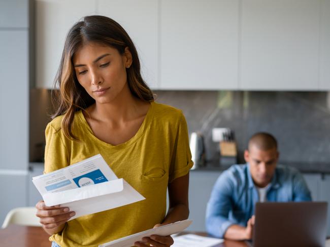 Portrait of a Latin American woman at home looking worried getting bills in the mail - domestic life concepts. **DESIGN ON DOCUMENTS BELONGS TO US**  - Picture iStock