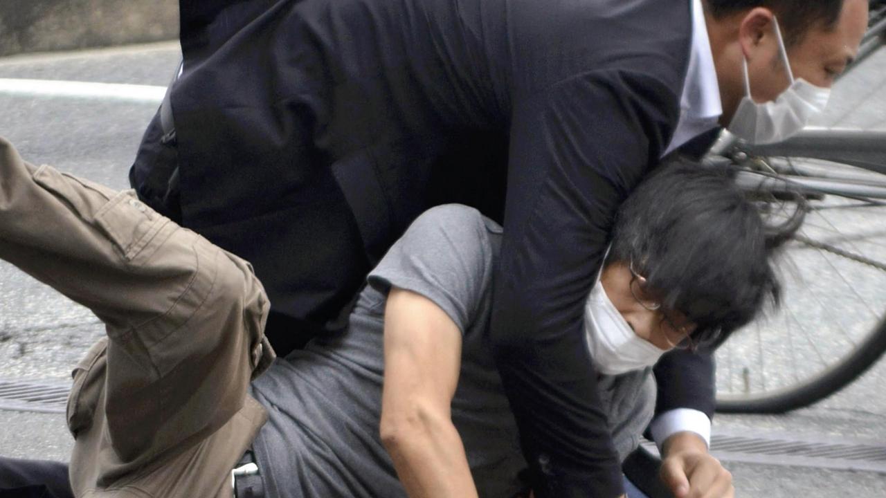 A man, believed to be a suspect, is seen being tackled to the ground. Picture: Takashi Yamazaki / Yomiuri / The Yomiuri Shimbun via AFP