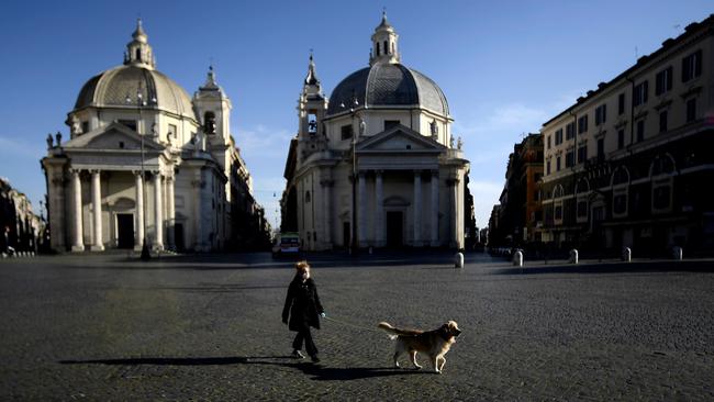 A woman takes her dog out in Piazza del Popolo in Rome. Picture: AFP