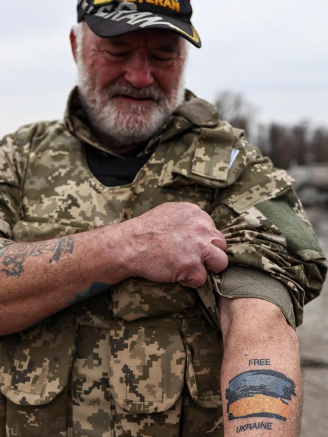 US war veteran Steven Straub shows his tattoo with the Ukranian flag as he patrols on a road near Buda-Babynetska, north of Kyiv. Picture: AFP