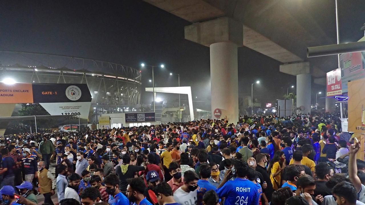 This picture shows spectators leaving the Narendra Modi Stadium without social distancing. (Photo by Sam PANTHAKY / AFP)