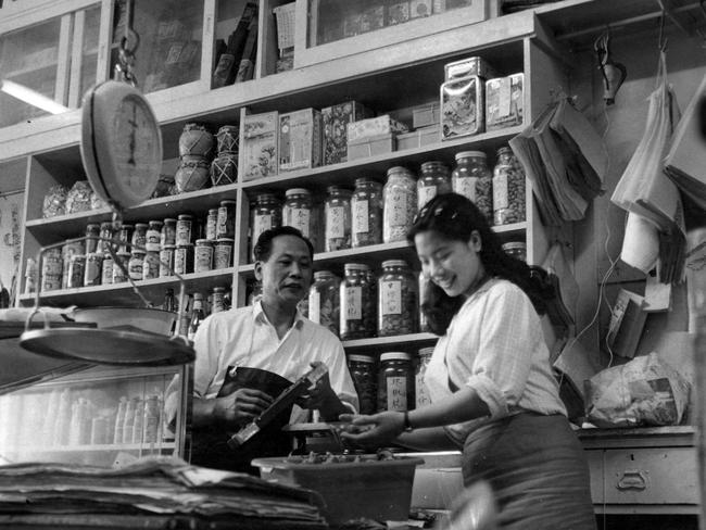 Marjorie Wong is selecting dried mushroom's in Wing Ying Cheong's store in Chinatown in 1963. Picture: HWT Library.