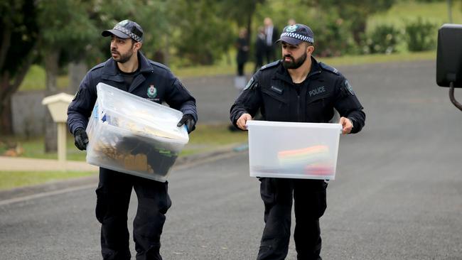 Officers carry boxes of items related to the search. Picture: Nathan Edwards