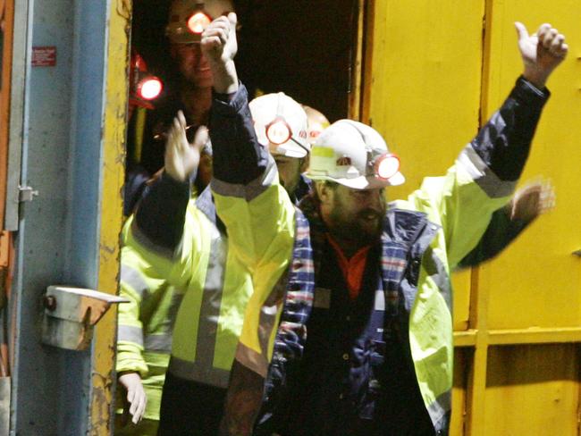 Tasmanian miners Todd Russell and Brant Webb (obscured) wave as they emerge from the mine lift having been rescued after being trapped underground at Beaconsfield gold mine for 14 days, May 9, 2006 in Beaconsfield, Australia. The two miners were involved in a mining accident 14 days ago after an earthquake caused a rock fall, but were found alive but trapped by fallen rocks almost one kilometre below the surface. Another miner, Larry Knight was killed in the accident. (Photo by Ian Waldie/Getty Images)