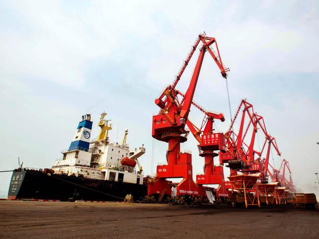 This photo taken on March 29, 2016 shows imported coal being unloaded from a cargo ship at a port in Lianyungang, east China's Jiangsu province.  Huge industrial overcapacity will drag on China's growth this year, the Asian Development Bank (ADB) said on March 30 as it cut its forecast for the world's second-largest economy. / AFP PHOTO / STR / China OUT