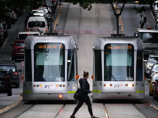 MELBOURNE, AUSTRALIA - NewsWire Photos DECEMBER 13, 2022: Photo a pedestrian walking in front of  trams in Collins street in Melbourne.Picture: NCA NewsWire / Luis Enrique Ascui
