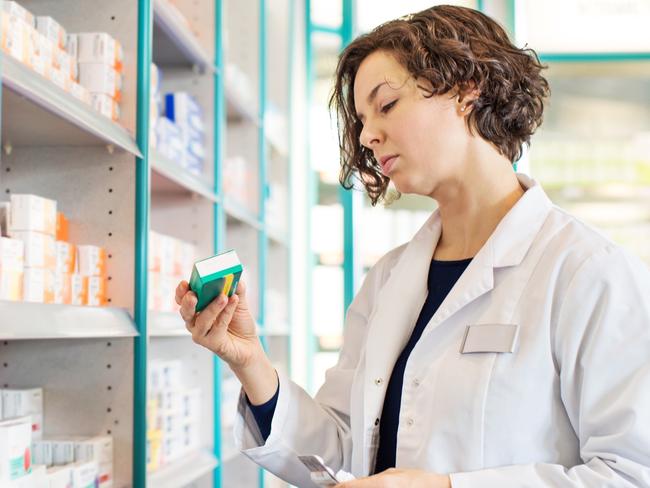 Generic photo of a pharmacist taking medicine from shelf at a  pharmacy. Picture: iStock