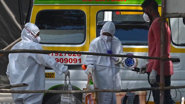 A health worker sanitises a patient’s bags at a coronavirus quarantine centre in Mumbai. Picture: AFP