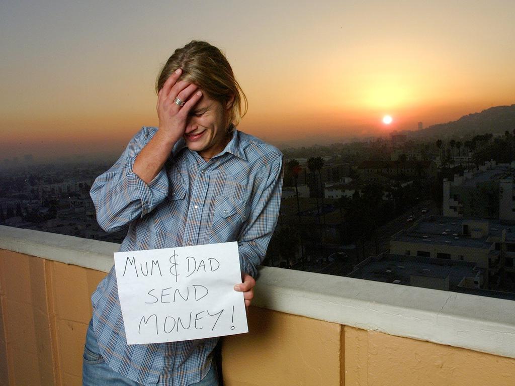 Fimmel, aged 22, holds a humorous sign for his parents back home on the balcony of his apartment in Hollywood, California. Picture: Paul Harris/Getty Images