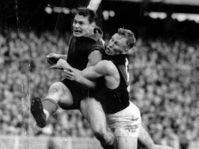 1957? Ron Barassi is tackled by Bob Suter. Melbourne v Essendon. Picture: GEORGE BUGDEN. HWT ARCHIVAL NEGATIVE.