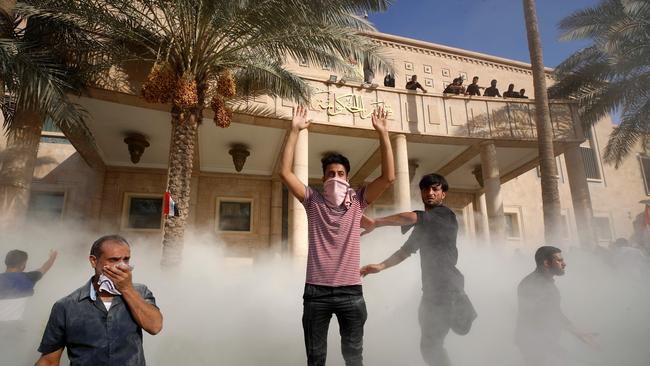 Sadr supporters are hit by teargas in Baghdad on Monday. Picture: AFP