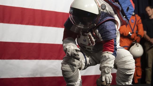 Kristine Dans bends down to pick up a rock during a demonstration of the mobility of the Exploration Extravehicular Mobility Unit (xEMU) Picture: AP