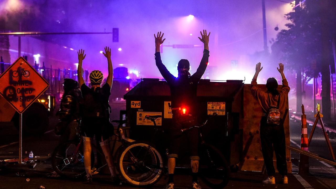 Protesters raise their hands during demonstrations on Friday. Picture: Chandan Khanna / AFP