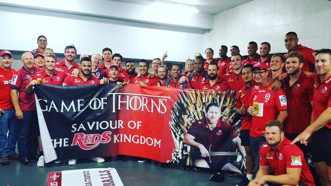 The Reds pose with a banner made by touring Queensland fans.