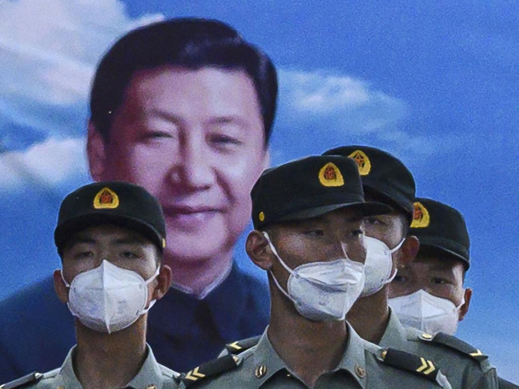 Soldiers of the People's Liberation Army's Honour Guard Battalion stand at attention in front of photo of China’s president Xi Jinping at their barracks outside the Forbidden City, near Tiananmen Square. Picture: Kevin Frayer / Getty Images