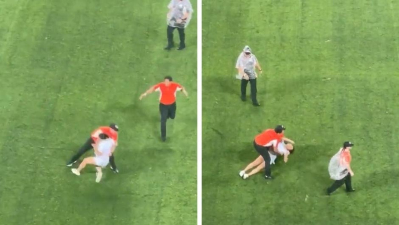 Footage of a female pitch invader getting brutally tackled by security staff at a football game has sparked debate on social media.