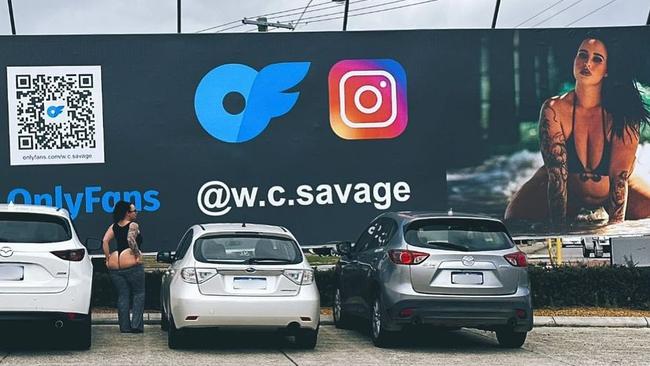 A giant OnlyFans billboard of adult entertainer Savannah pictured with the billboard which had copped hundreds of complaints. Picture: Instagram