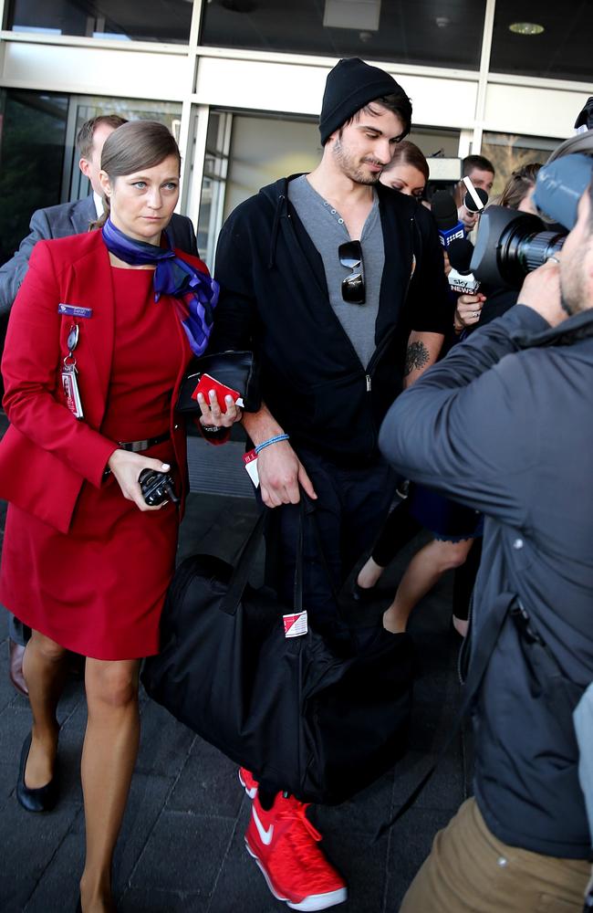 Scott Broadbridge is escorted to a waiting bus by a Virgin employee. Picture: John Grainger.
