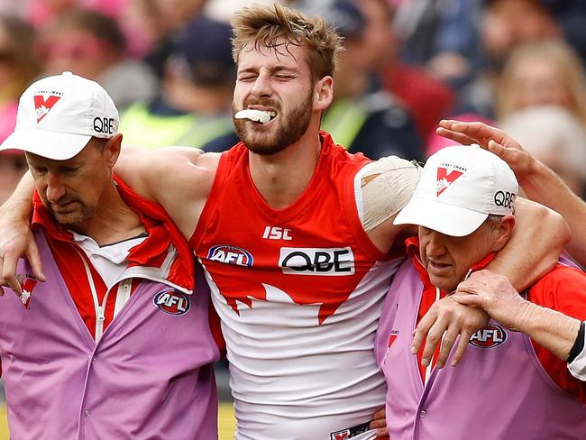 MELBOURNE, AUSTRALIA - AUGUST 12: Nick Smith of the Swans consoles Alex Johnson of the Swans as he leaves the field injured during the 2018 AFL round 21 Pink Lady match between the Melbourne Demons and the Sydney Swans at the Melbourne Cricket Ground on August 12, 2018 in Melbourne, Australia. (Photo by Adam Trafford/AFL Media/Getty Images)