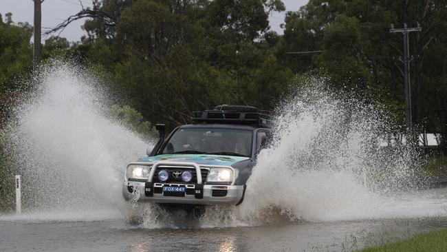 A car drives through flood waters in Pitt Town, Australia. Picture: Brook Mitchell