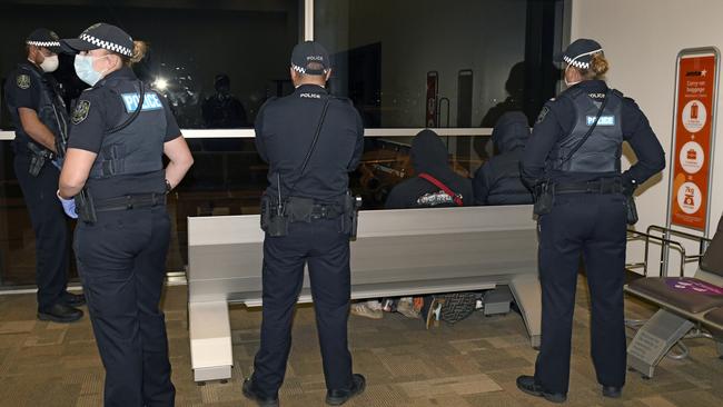 The train stowaways under police escort at Adelaide Airport. They flew back to Melbourne on Thursday night. Picture: NCA NewsWire / Naomi Jellicoe