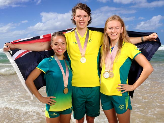 Jemima Montag, Kelland O’Brien and Ariarne Titmus show off their medals on the beach at the Gold Coast. Picture: Alex Coppel