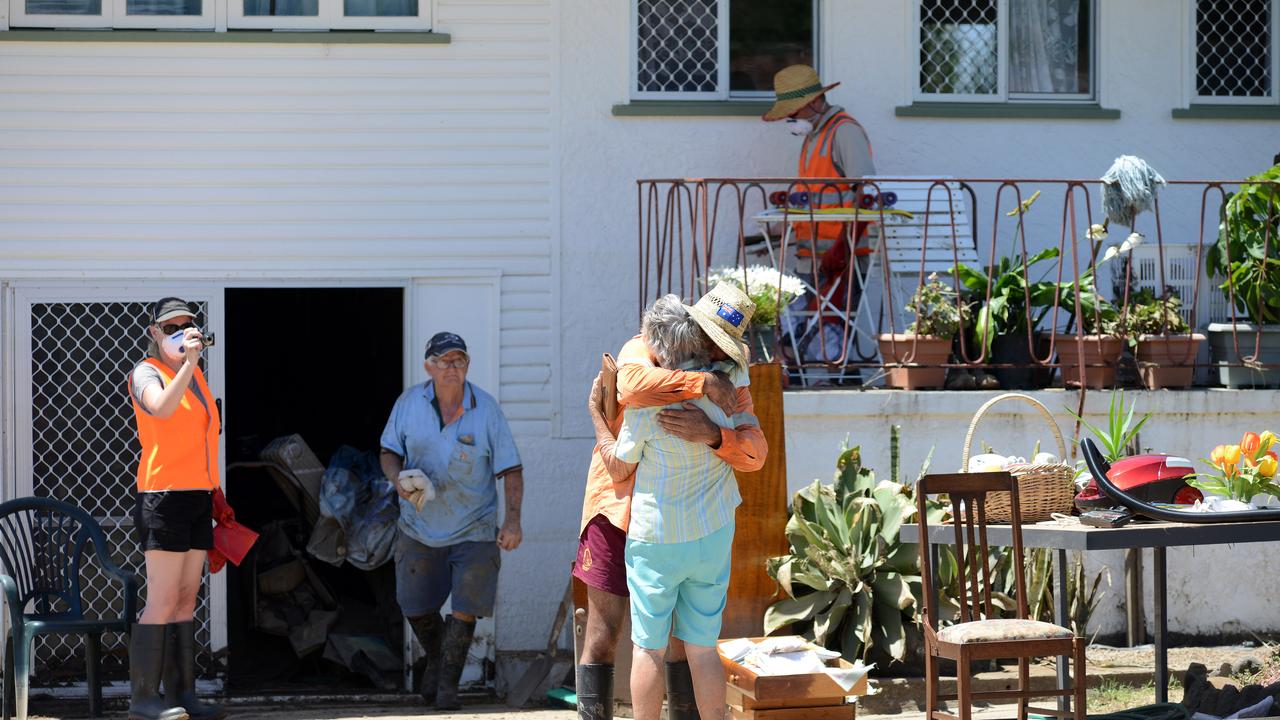 Two residents embrace each other in Bundaberg, Saturday, Feb. 2, 2013. Residents of the hardest hit suburb in Queensland's flood crisis have begun the heartbreaking journey of returning home to assess damage after police opened the Burnett Bridge to north Bundaberg residents at 6am. (AAP Image/Paul Beutel) NO ARCHIVING