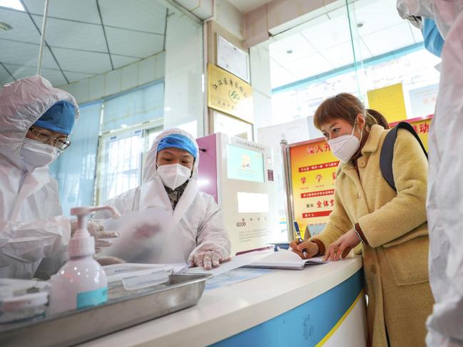 Medical workers talking with a woman suspected of being ill with a coronavirus in Wuhan. Picture: Chinatopix via AP