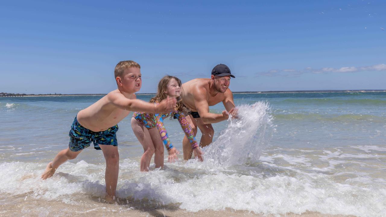 Adam James of Sheidow Park SA with his children Nixon 7, and Lexington, 5 are still enjoying the water. Picture: NCA NewsWire / Ben Clark